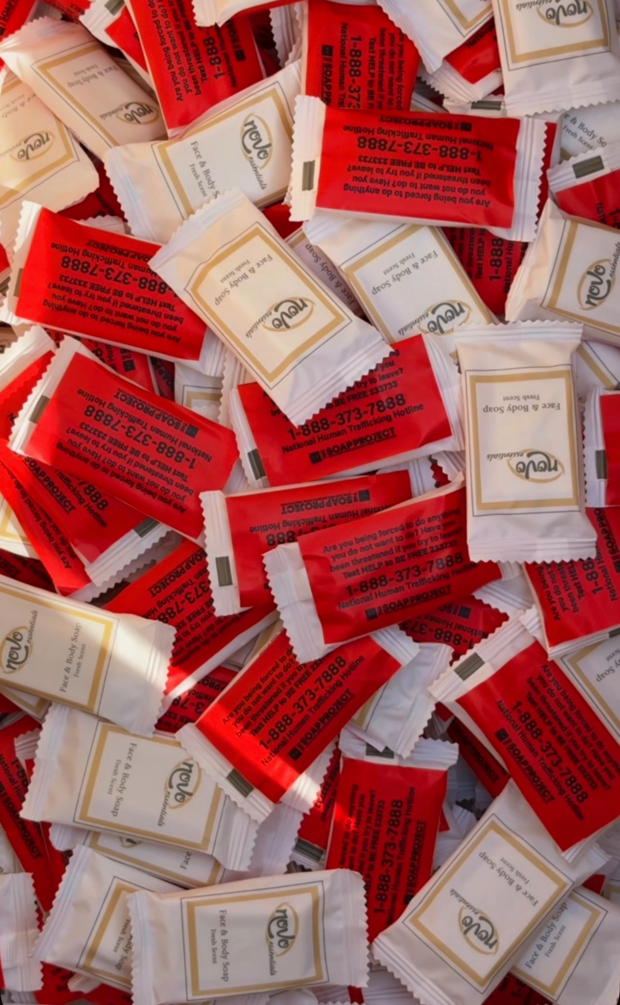 Individually wrapped bars of soap with red SOAP Project labels displaying the National Human Trafficking Hotline.